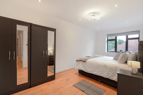 寇斯顿Modern Comfort Two Bedrooms Flat, Coulsdon CR5的一间卧室配有一张大床和镜子