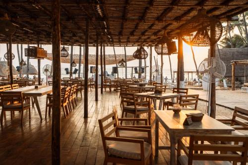 戈阿韦尔哈Thalassa Beach Boutique Resort的一间空餐厅,配有木桌和椅子