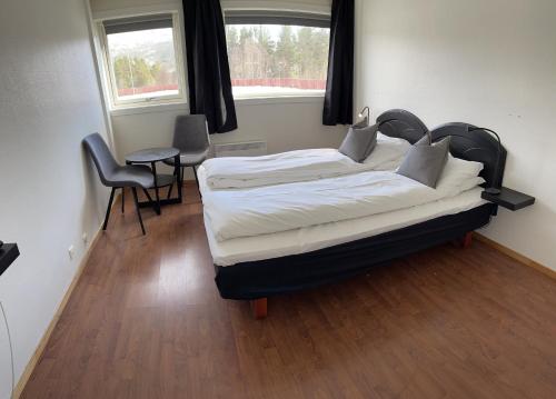 奥普达尔Oppdalsporten Motell的卧室配有一张床和一张桌子及椅子