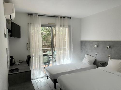滨海阿热莱斯Acapella Hotel的酒店客房设有两张床和一个阳台。