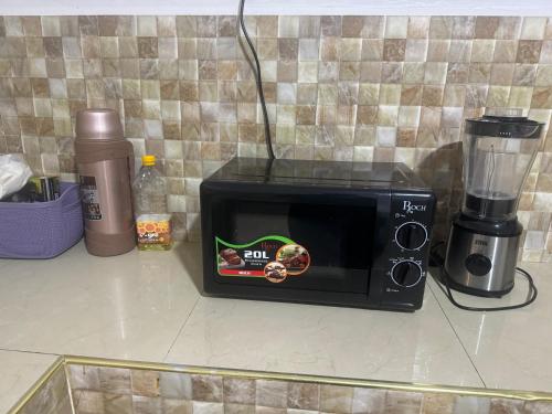 莫罗戈罗Winnie's Home的一台带搅拌机的台面上的黑微波炉