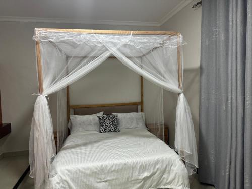 莫罗戈罗Winnie's Home的卧室内的一张带天蓬的床