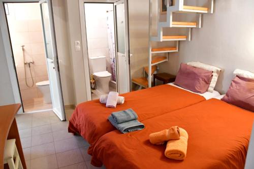 爱琴娜岛卡洛肯提公寓的一间卧室配有橙色床和毛巾