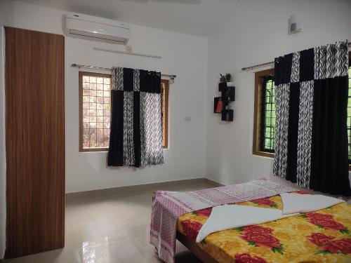 蒙纳Munnar Village Homes的一间卧室设有一张床和两个窗户。