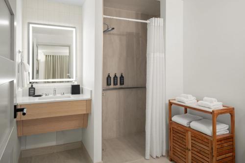 克利尔沃特Sheraton Sand Key Resort的浴室配有盥洗盆和带镜子的淋浴