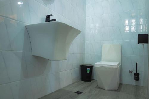 KasoaCMP APARTMENTS的白色的浴室设有卫生间和垃圾桶