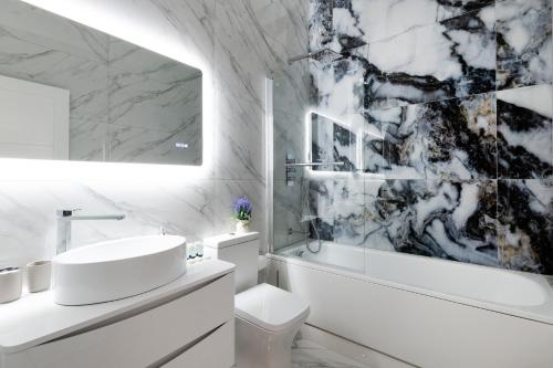 寇斯顿Refined Living: Three Bedrooms Flat in Coulsdon CR5的白色的浴室设有水槽和卫生间。
