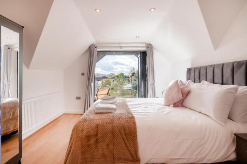 寇斯顿Refined Living: Three Bedrooms Flat in Coulsdon CR5的白色的卧室设有一张大床和一个窗户
