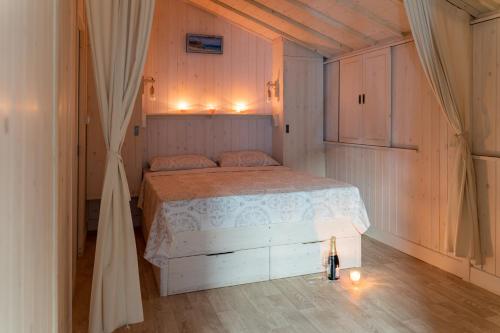 维琪奥港Camping Arutoli的卧室铺有木地板,配有白色的床。