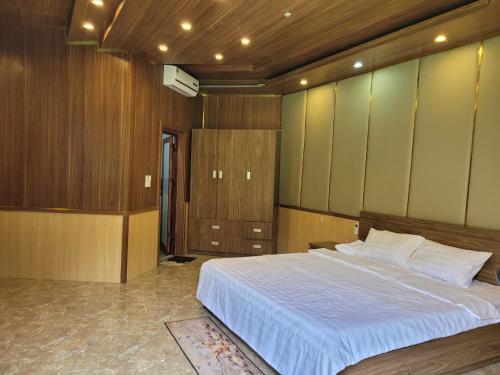 Ban Hin LomKhu nghỉ dưỡng GOOD TIME的一间卧室设有一张大床和木墙