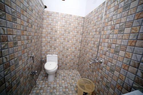 卡拉奇Seasons Inn的一间带卫生间和瓷砖墙的浴室