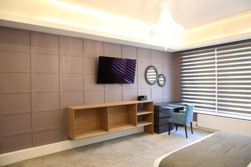 赫特福德Ponsbourne Park的一间房间,配有一张桌子和一台墙上的电视