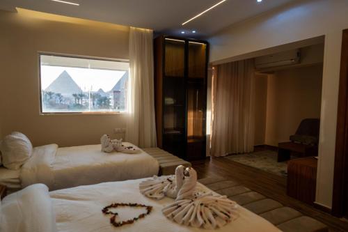 开罗Tuya Pyramids Inn的酒店客房设有两张床和窗户。