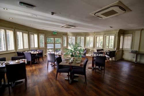 滨海绍森德罗奇福德酒店的用餐室设有桌椅和窗户。