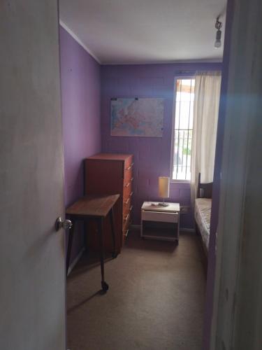 拉塞雷纳Pieza individual con baño privado en sector Puertas del mar的一间卧室设有紫色的墙壁、一张床和一张书桌