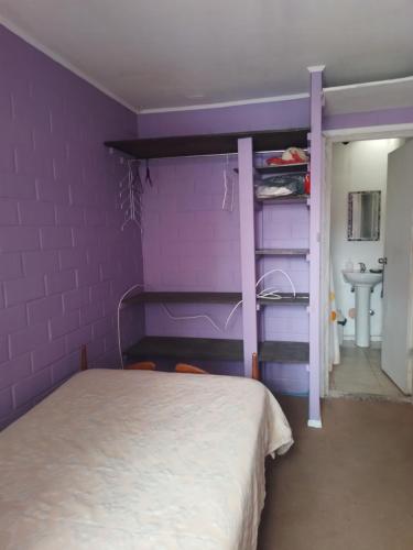 拉塞雷纳Pieza individual con baño privado en sector Puertas del mar的紫色卧室配有一张床和一个水槽