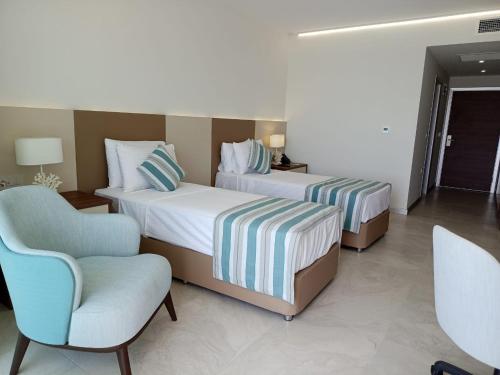 吉布提Gadileh Resort Hotel的酒店客房,配有两张床和椅子