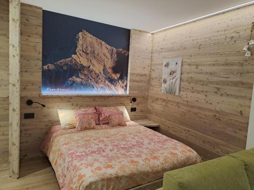 莱维科特尔梅Monolocale La Rosa的卧室配有一张床,墙上挂有绘画作品