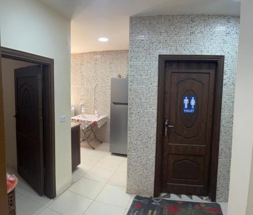 卡拉克Al Karak House的带冰箱的厨房设有两扇木门