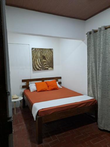 利比里亚Hostel Casa Mar的一间卧室配有带橙色枕头的床