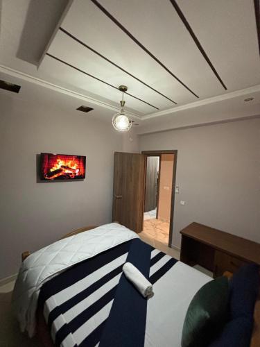 马拉喀什Résidence les Jardin d Anass Aéroport Marrakech的卧室配有一张床,墙上配有电视。