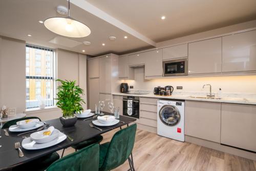 利兹Luxury Serviced Penthouse - City Centre - En Suite Bedrooms - Free Netflix的厨房以及带桌椅的用餐室。