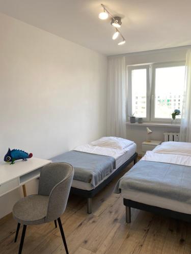 瓦乌布日赫Apartament Kasia的一间卧室配有两张床、一张桌子和一把椅子