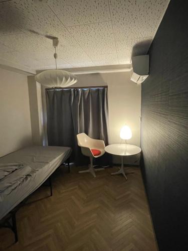 SaikiHostel UND BASE的配有床、桌子和椅子的房间