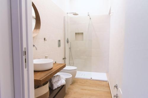 里里耶沃Cocci di tufo Appartamenti的一间带水槽、卫生间和淋浴的浴室