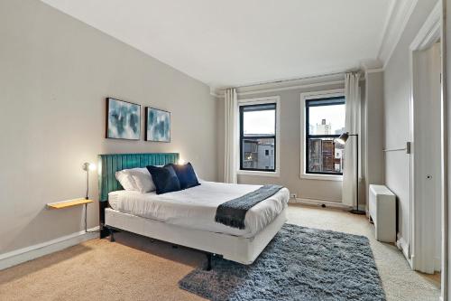 芝加哥Elegant 1-Bedroom Apartment in Hyde Park - Windermere 310的一间卧室设有一张大床和两个窗户。