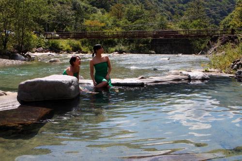 高山深山荘的两个女人坐在河里的岩石上