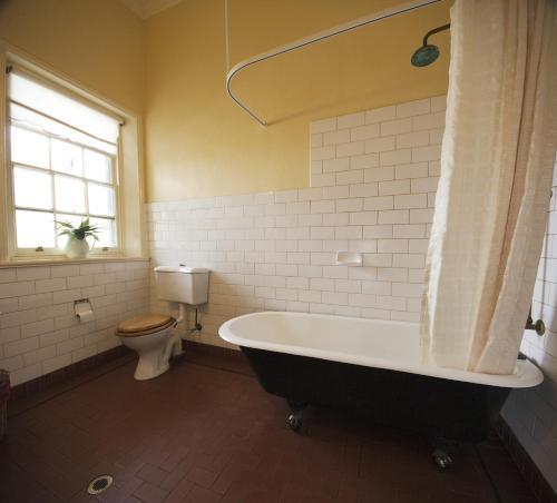 Auburn旭日酒店 的带浴缸和卫生间的浴室。