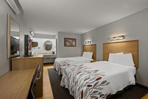 格林斯伯勒Red Roof Inn Greensboro Airport的酒店客房设有两张床和一台平面电视。