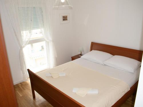 柳布什基An apartment M & K - 70 m2的一间卧室配有一张带两个白色枕头的床和一扇窗户。