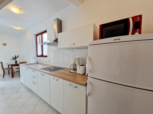 波雷奇Villa Aleksandar Porec的厨房配有白色橱柜和冰箱。