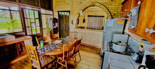 SiguatepequeVilla Isabella, La Sucursal del Cielo的厨房配有木桌和冰箱。