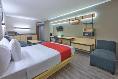 墨西哥城墨西哥爱普雷多城市快捷酒店的酒店客房配有一张床、一张桌子和一把椅子。