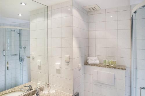 德累斯顿德累斯顿德勒斯登万怡酒店的带淋浴和盥洗盆的白色浴室