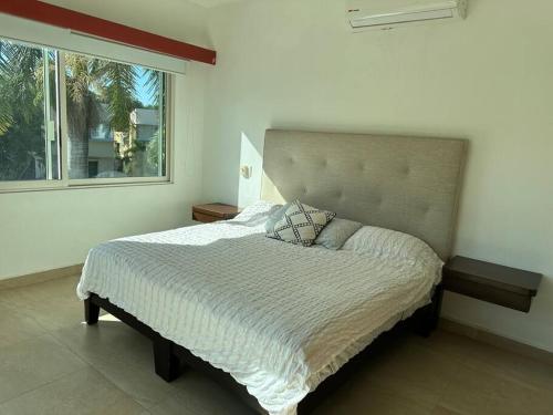 巴亚尔塔港Casa hermosa y acogedora en condominio privado的卧室内的一张床铺,设有大窗户