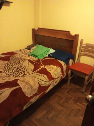 基多El Hogar de Jhonny的一张床位,房间配有红色椅子和一张四柱床