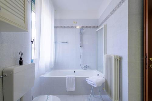 松德里奥Revo Apartments - Quadrifoglio的白色的浴室设有浴缸和淋浴。