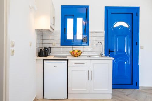 雷夫科斯卡尔帕索Corali Studios的厨房配有蓝色橱柜和水槽
