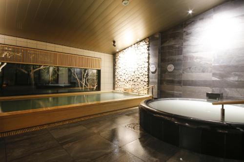 志摩市纳姆度假酒店的带浴缸和浴缸的浴室。