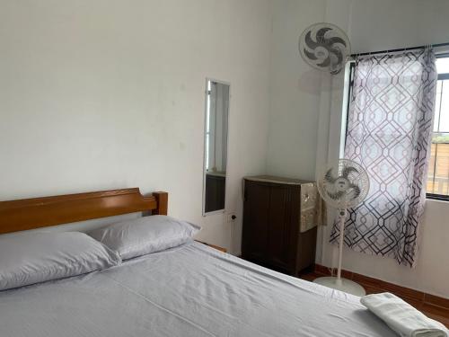 莱蒂西亚OASIS的卧室配有1张床、风扇和窗户。