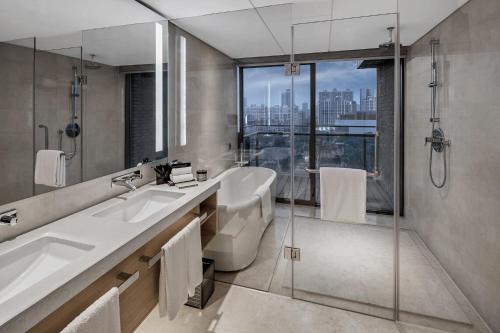 佛山佛山岭南天地康得思酒店-广交会免费穿梭巴士的一间带两个盥洗盆和淋浴的浴室