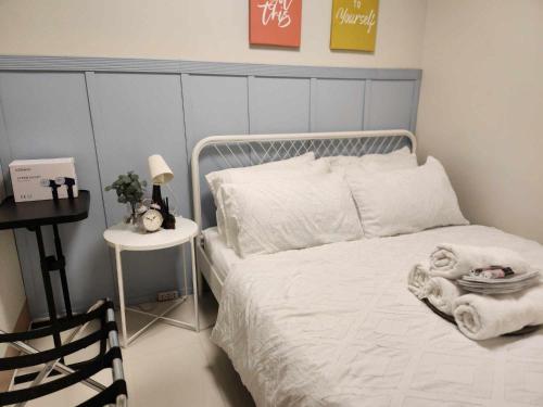 马尼拉My Humble Abode at Shore 3的卧室配有白色的床和床头柜