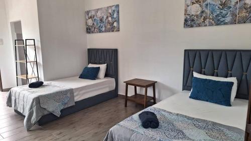 Kampung MawarOcean Cottage 2, Radiant Teluk Sari的一间卧室配有两张带蓝色枕头的床