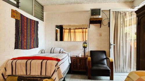 帕纳哈切尔Royal Palace Hostal的一间卧室配有一张床、一把椅子和镜子