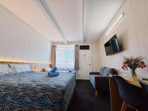 西摩西摩汽车旅馆 的卧室配有蓝色泰迪熊,坐在床上