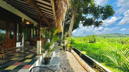 日惹Villa Sare - House with panorama rice field view的一个带格子地板的房子的门廊